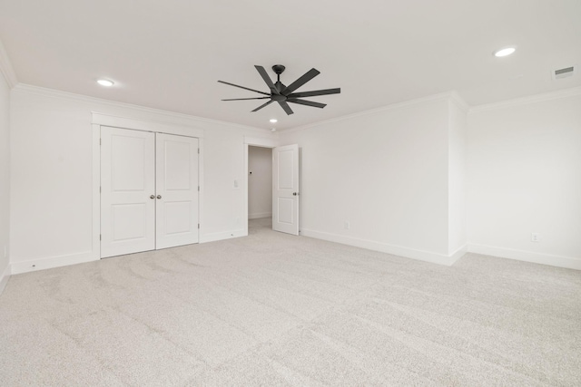 unfurnished bedroom featuring a closet, ceiling fan, crown molding, and light carpet