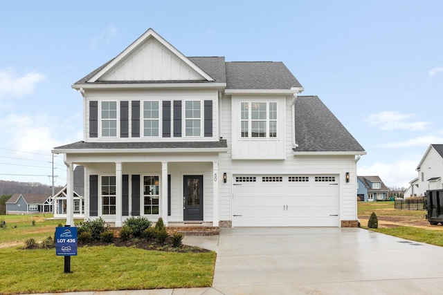 view of front of home featuring a front yard, a porch, and a garage