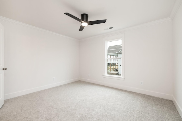 carpeted spare room with ceiling fan and ornamental molding