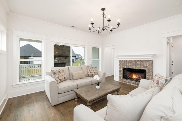 living room with dark hardwood / wood-style flooring, ornamental molding, a fireplace, and a chandelier