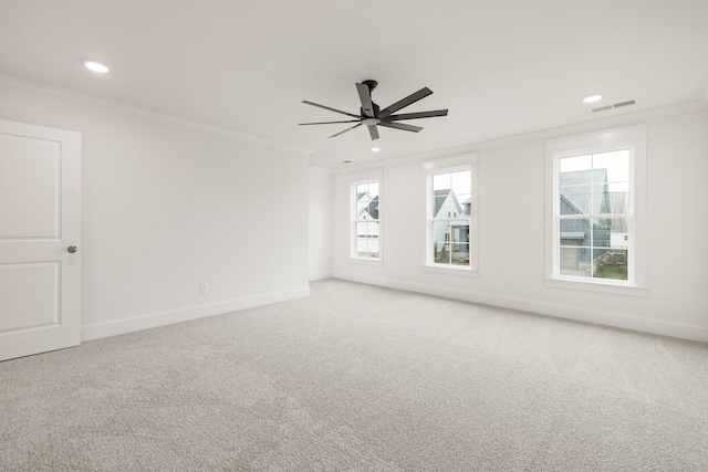 carpeted spare room featuring a healthy amount of sunlight, ceiling fan, and crown molding