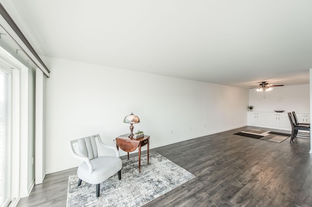 sitting room with ceiling fan and dark hardwood / wood-style flooring