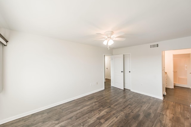 unfurnished bedroom featuring ceiling fan, ensuite bathroom, and dark hardwood / wood-style floors