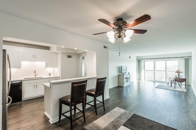 kitchen with white cabinetry, sink, ceiling fan, dark hardwood / wood-style floors, and a kitchen bar