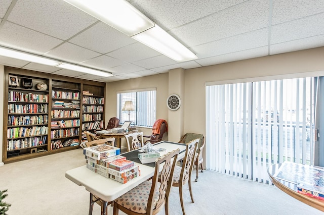 dining room featuring carpet flooring, a drop ceiling, and built in features