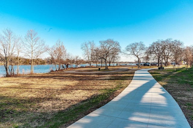 surrounding community featuring a water view and a lawn