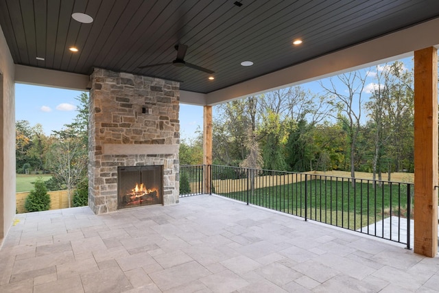 view of patio featuring an outdoor stone fireplace and ceiling fan