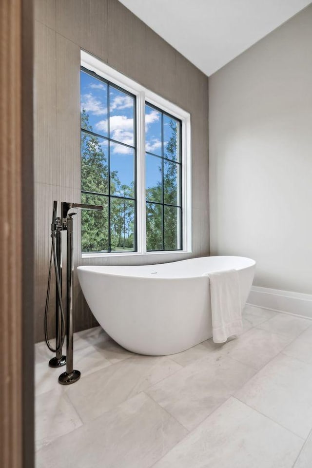 bathroom featuring a tub to relax in and a wealth of natural light