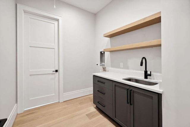 interior space with gray cabinets, sink, and light hardwood / wood-style floors