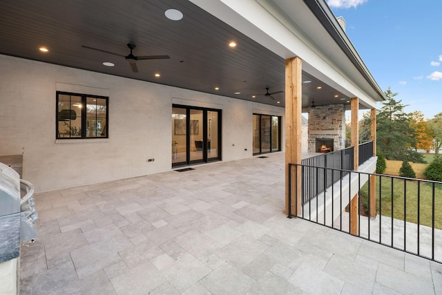 view of patio / terrace with ceiling fan and an outdoor fireplace