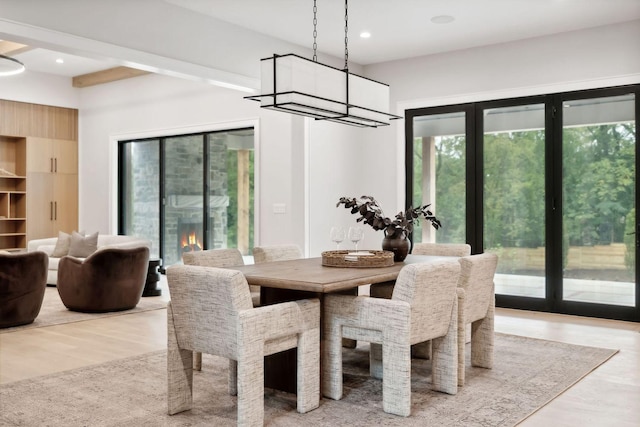 dining area with a large fireplace and light hardwood / wood-style flooring