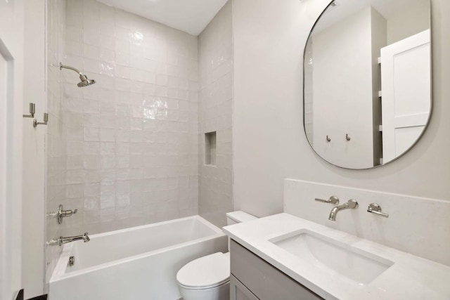 full bathroom featuring tiled shower / bath combo, toilet, and vanity