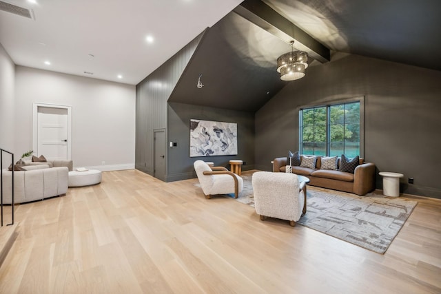 living room featuring vaulted ceiling with beams, light hardwood / wood-style floors, and a chandelier