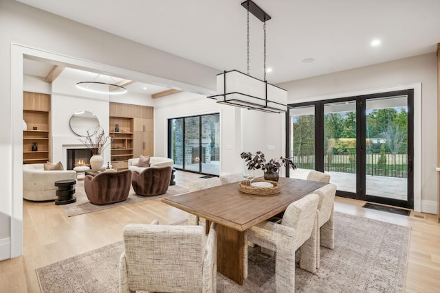 dining area featuring built in features, light wood-type flooring, and french doors