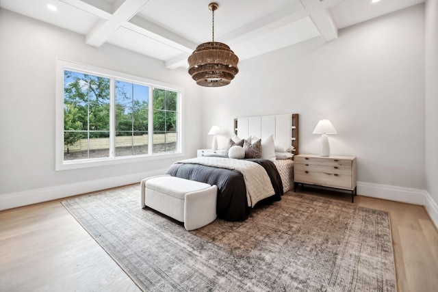 bedroom featuring beamed ceiling, wood-type flooring, and coffered ceiling