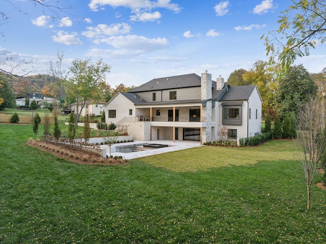 back of house with a lawn, a patio area, and a balcony