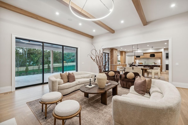 living room featuring beam ceiling and light hardwood / wood-style flooring