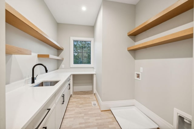 laundry area featuring washer hookup, cabinets, and sink