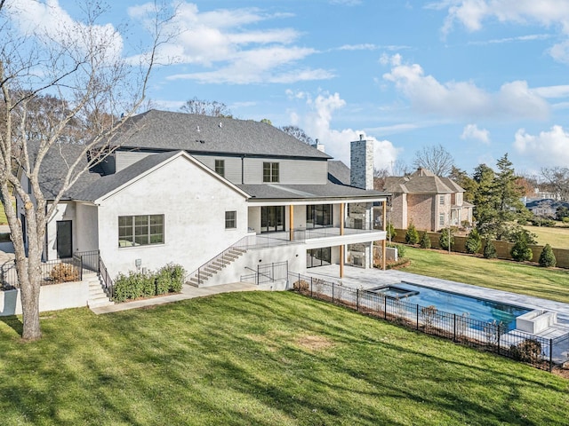 rear view of property with a yard, a patio, a covered pool, and a sunroom