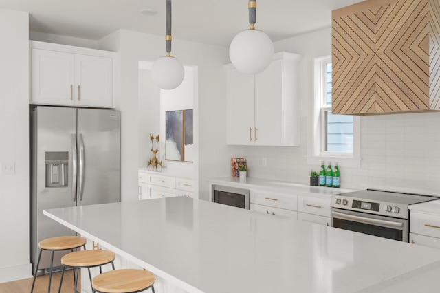 kitchen featuring decorative backsplash, stainless steel appliances, exhaust hood, pendant lighting, and white cabinets