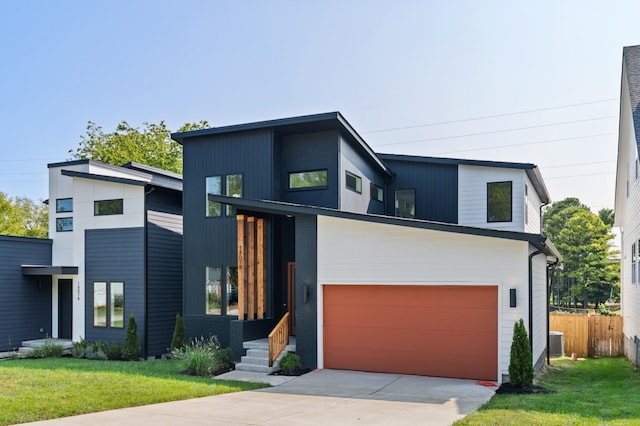 contemporary home featuring central AC unit, a garage, and a front yard