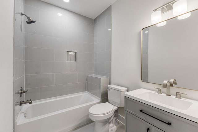 full bathroom with tiled shower / bath, vanity, and toilet