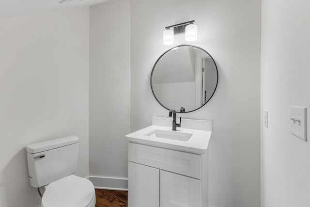 bathroom with hardwood / wood-style flooring, vanity, and toilet