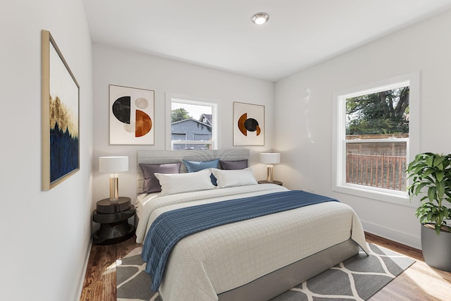 bedroom featuring multiple windows and light hardwood / wood-style flooring