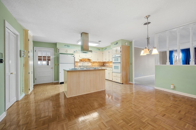 kitchen featuring island exhaust hood, backsplash, white appliances, decorative light fixtures, and a notable chandelier