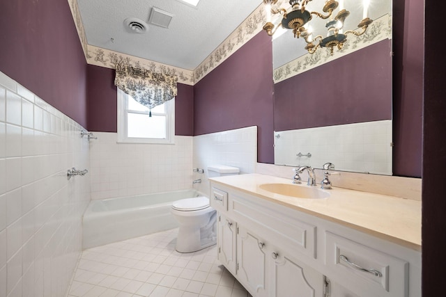 bathroom with a bathing tub, tile patterned flooring, a textured ceiling, toilet, and vanity