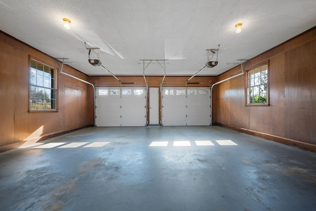 garage with a garage door opener and wooden walls