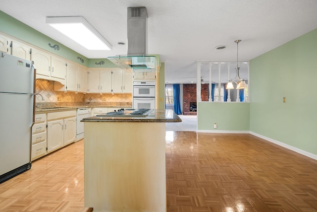 kitchen with white appliances, sink, a textured ceiling, a kitchen island, and extractor fan