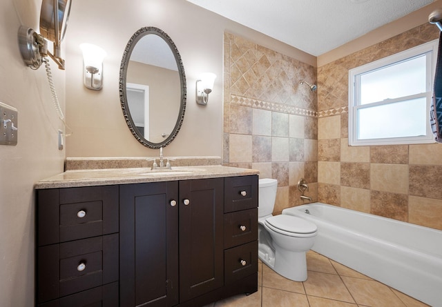 full bathroom featuring vanity, tile patterned floors, tiled shower / bath combo, and toilet