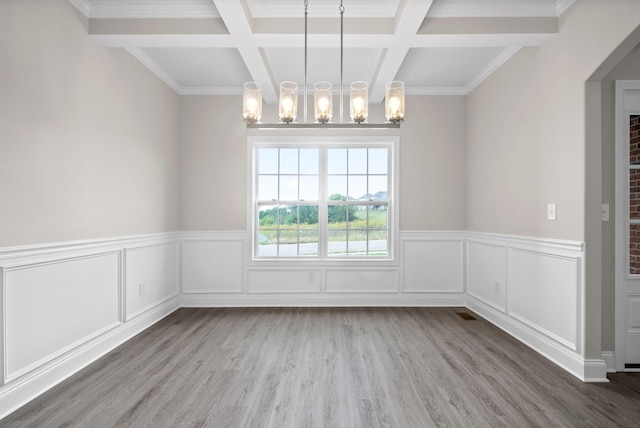 unfurnished dining area featuring a chandelier, beam ceiling, and coffered ceiling