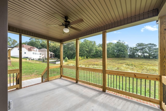 unfurnished sunroom with ceiling fan