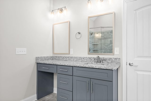 bathroom featuring a shower with door and vanity