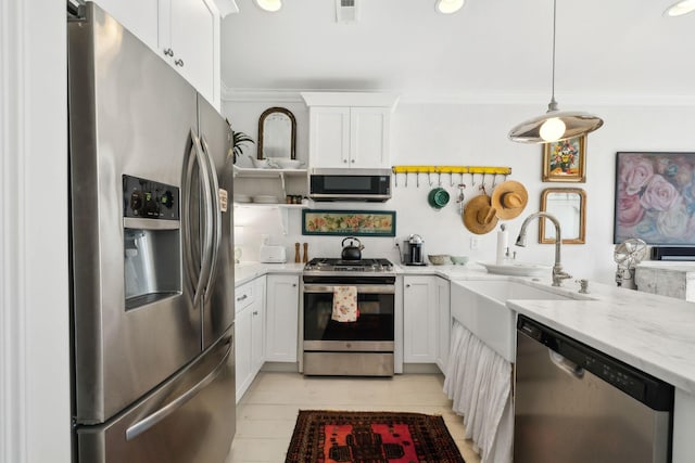 kitchen with sink, hanging light fixtures, light stone countertops, white cabinetry, and stainless steel appliances