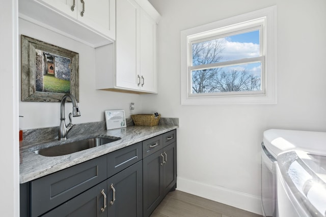 laundry room with washer and dryer, sink, and cabinets