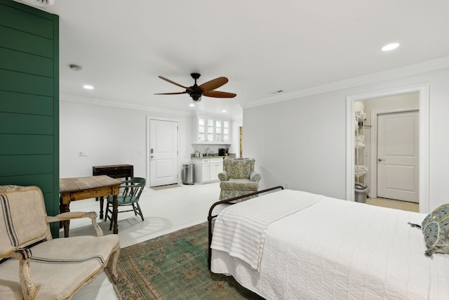 bedroom with ceiling fan, ornamental molding, sink, and connected bathroom