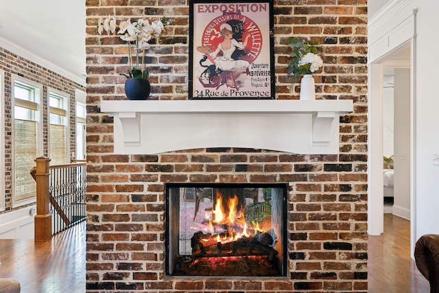 details with hardwood / wood-style flooring, ornamental molding, and a fireplace