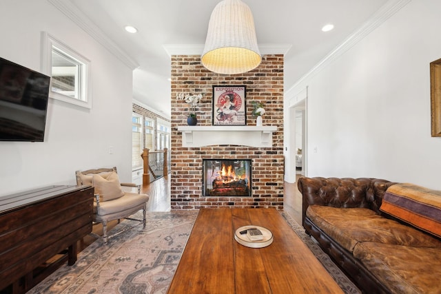 living room featuring hardwood / wood-style floors, a fireplace, and crown molding