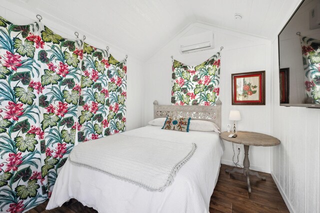 bedroom featuring a wall mounted air conditioner, dark hardwood / wood-style floors, and lofted ceiling