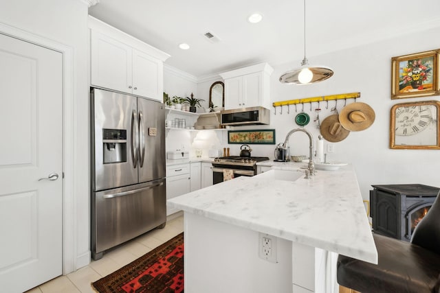 kitchen featuring pendant lighting, white cabinets, a kitchen breakfast bar, light tile patterned flooring, and stainless steel appliances