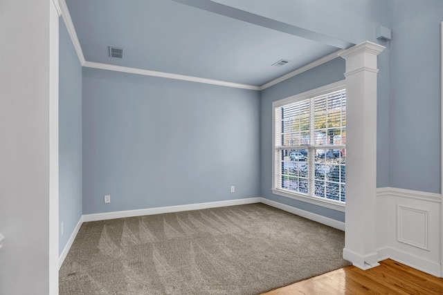 carpeted empty room with ornate columns and crown molding