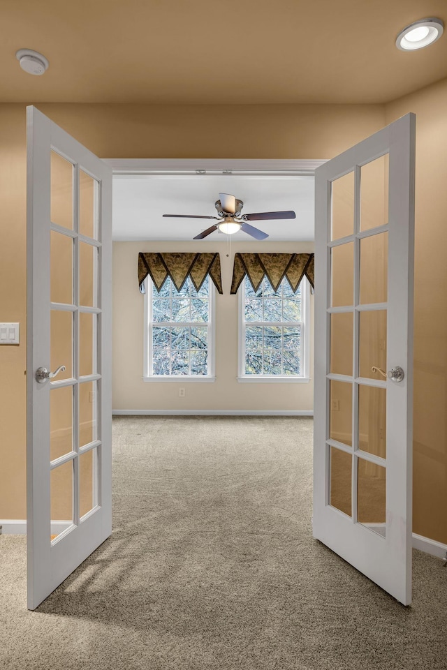 carpeted empty room featuring ceiling fan and french doors