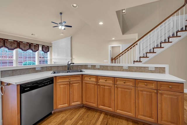 kitchen featuring stainless steel dishwasher, vaulted ceiling, ceiling fan, sink, and light hardwood / wood-style floors