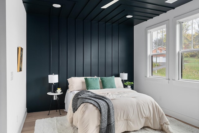 bedroom with lofted ceiling and light wood-type flooring