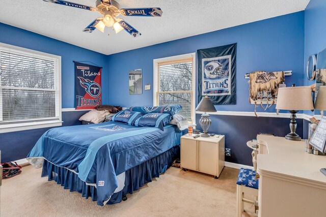 carpeted bedroom featuring a textured ceiling and ceiling fan