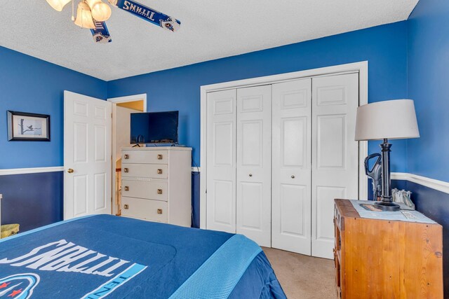 bedroom featuring a textured ceiling, a closet, ceiling fan, and carpet floors