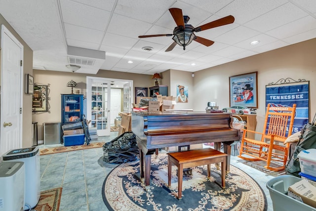 miscellaneous room featuring tile patterned flooring, ceiling fan, and a drop ceiling